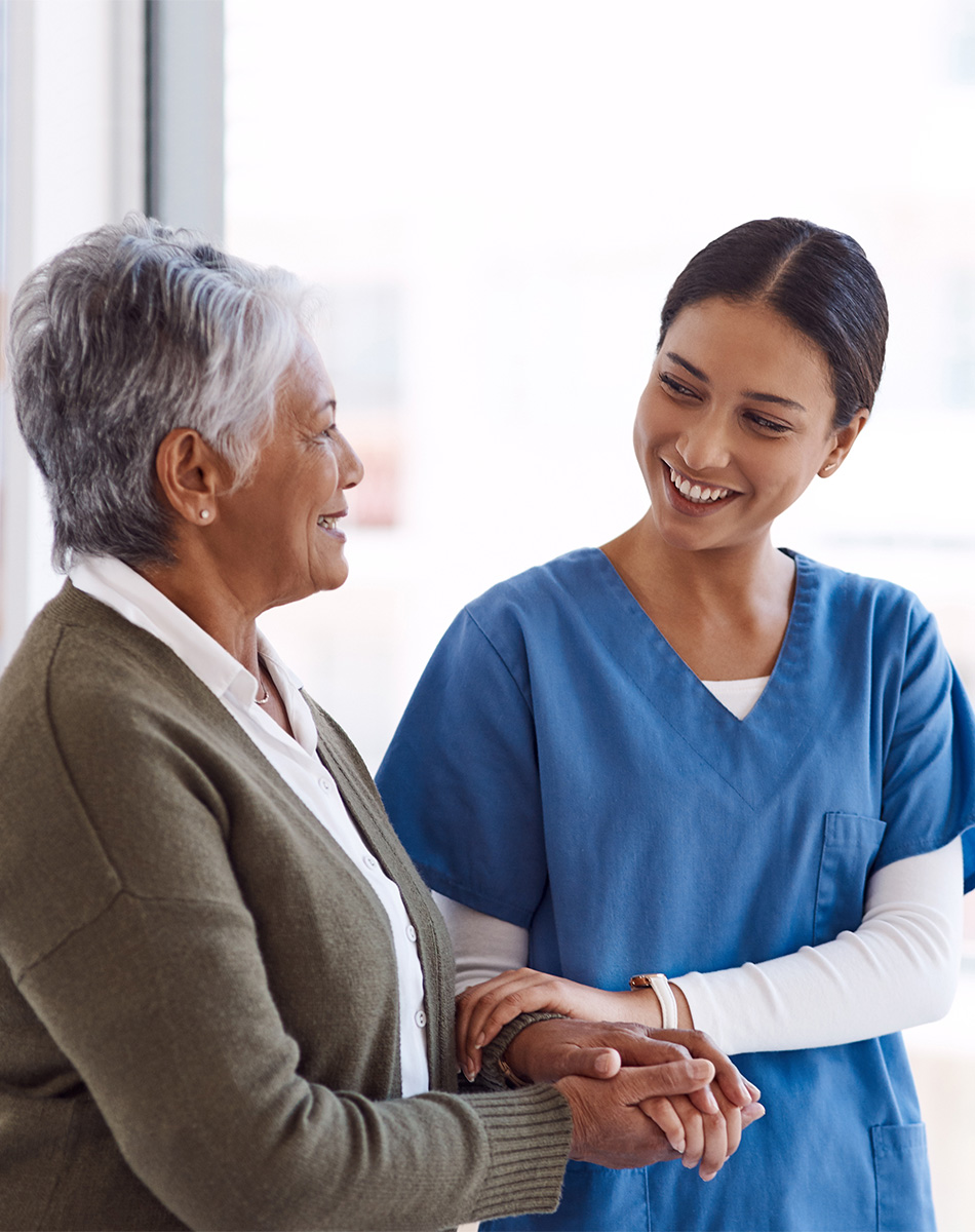 Nurse and resident speaking and walking arm in arm.