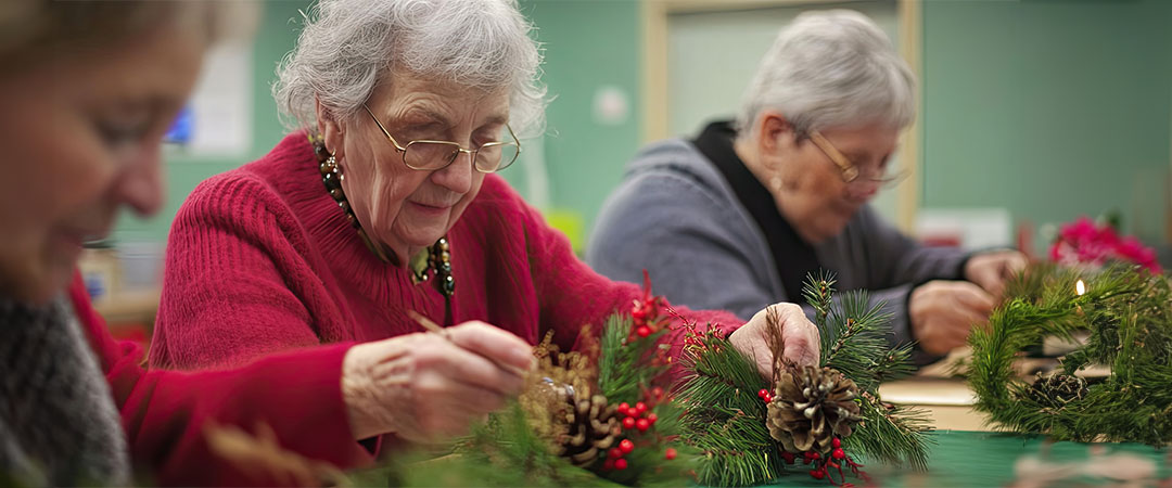 Seniors doing holiday crafts together at a table.